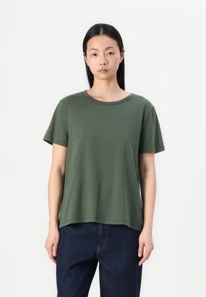 Green short-sleeve t-shirt with a rounded neckline. Made of soft fabric, relaxed fit, and a straight hem, paired with blue jeans.