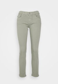 Jeans ajustados de color verde claro con una cinturilla de altura media, cinco bolsillos y detalles de costura sutiles. Fabricados con una mezcla de algodón elástico.