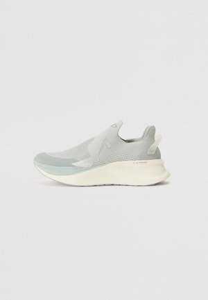 Jasnoszary sneaker typu slip-on z siateczkową powierzchnią, podwyższoną białą podeszwą i zawieszką na pięcie, pokazany z boku na jednolitym tle.