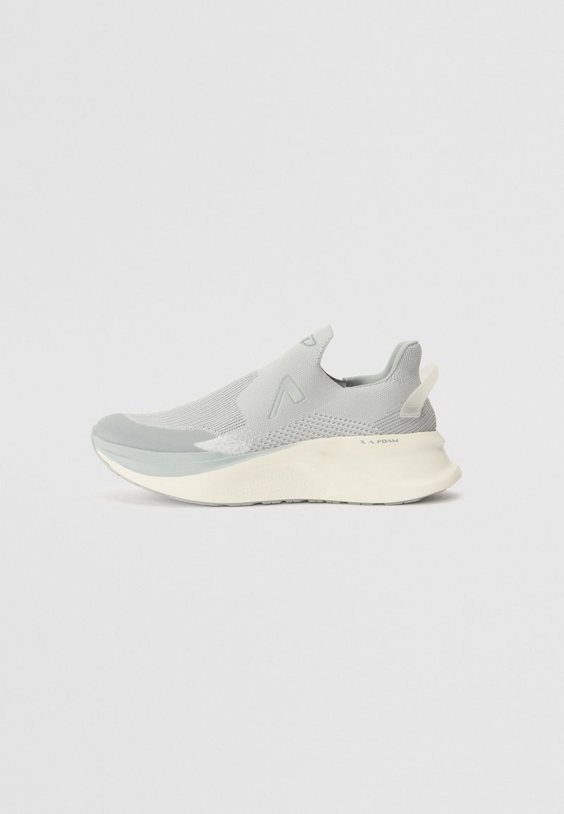 Baskets slip-on gris clair avec tige en mesh, semelle blanche surélevée et languette au talon, vues de côté sur un fond uni.