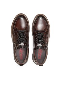 Zapatos de cuero marrón con punta redonda, acentos texturizados, cordones negros, cremallera lateral y logotipo rojo en la plantilla. Acabado suave.