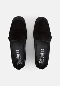 Black suede loafers with a slightly raised heel, featuring a stitched design and a smooth inner lining. Logo printed inside.