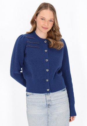 Cardigan lavorato a maglia blu con bottoni a forma di cuore, polsini a coste e decorazioni in perline sulle spalle. Texture morbida, design aderente.