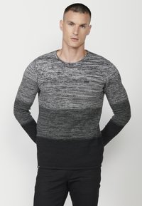 Pulover cu guler rotund, în nuanțe degradate de gri, având un model tricotat texturat, manșete cu nervuri și bază solidă neagră.
