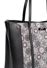 Zwarte totebag met een geometrisch patroon van grijze stof met bloemmotieven; bevat een gladde leren textuur en gouden logo-accent.