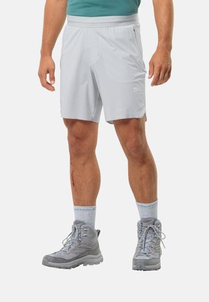 Shorts gris clair avec taille élastique et une poche latérale, associés à des bottes de randonnée grises et des chaussettes de crew gris clair.