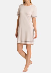 Robe da notte corta a maniche corte color beige chiaro con una vestibilità rilassata, caratterizzata da rifiniture nere sulle maniche e sull'orlo, realizzata in tessuto morbido.