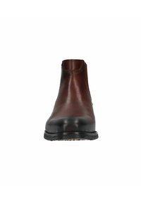 Bottine en cuir marron avec une finition lisse, un bout arrondi et un minimum de détails de couture. Semelle en caoutchouc noire avec une légère élévation du talon.