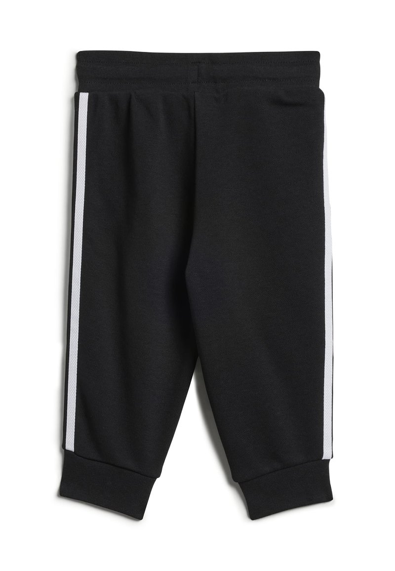 Pantaloni sportivi neri in tessuto misto cotone con strisce laterali bianche. Presentano una vita elastica e polsini affusolati alle caviglie.