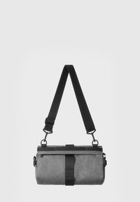 Gray fabric crossbody bag with a cylindrical shape, adjustable black strap, and a black accent band for secure closure.