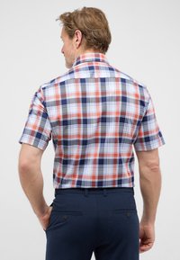 Camicia a maniche corte a quadri con motivi rosso, blu, bianco e grigio, dotata di colletto strutturato, realizzata in tessuto di cotone leggero.