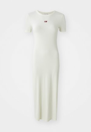 Abito a coste, lungo fino alla caviglia, di colore verde chiaro con maniche corte e scollo rotondo, caratterizzato da un piccolo logo ricamato in rosso sul petto.