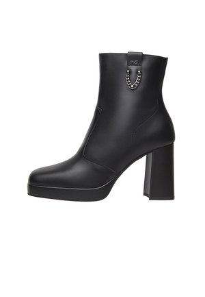 Zwarte enkelboot van glad leer, met een chunky blokhak, ronde neus en een metalen kettingdetail aan de achterkant.