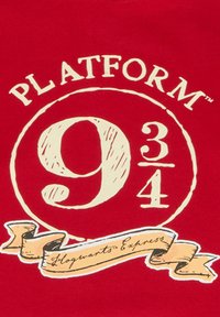 Tissu rouge avec un motif circulaire de couleur crème présentant "PLATFORM 9¾" et "Hogwarts Express" sur un ruban. Détails de lettrage texturé.