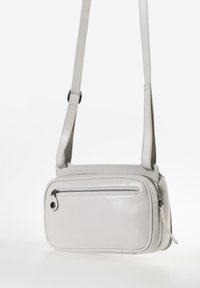 Borsa a tracolla grigia in pelle con forma rettangolare, tracolla regolabile, tasca frontale con zip e dettagli di cucitura sottili.