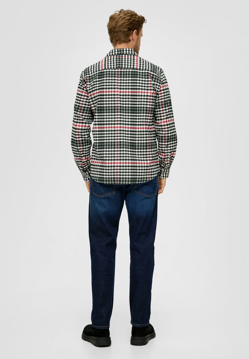 Koszula w kratę z długim rękawem w kolorach czarnym, zielonym i białym, z czerwonymi akcentami, wykonana z materiału o gładkiej fakturze, w połączeniu z ciemnymi dżinsami.