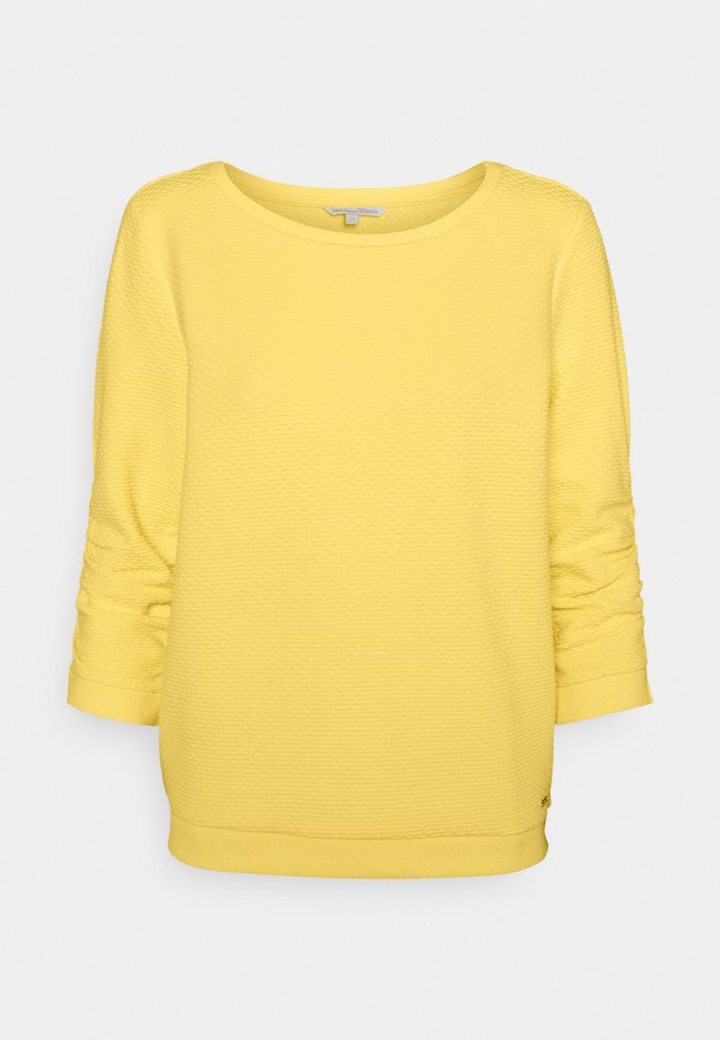 Pull jaune texturé à manches longues avec col rond et bords-côtes aux poignets et à l’ourlet, présenté sur un fond clair uni.