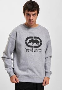 Gray sweatshirt made from cotton blend, featuring a black graphic of a rhinoceros and brand text. Loose fit with crew neckline and ribbed cuffs.