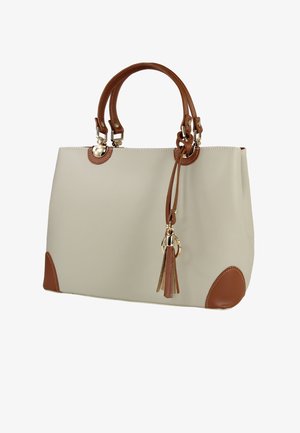 Beige draagtas met bruine accenten, inclusief handvatten en hoekstukken. Voorzien van goudkleurige hardware en een decoratieve kwastdetail. Gladde textuur.