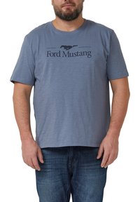 Niebieska bawełniana koszulka z krótkimi rękawami, z grafiką galopującego konia i napisem "Ford Mustang" w ciemnoniebieskim kolorze.