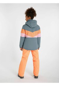 Veste d'hiver colorée en gris avec des rayures en chevrons orange et rose, assortie à un pantalon orange vif et une capuche. Tissu texturé, coupe décontractée.