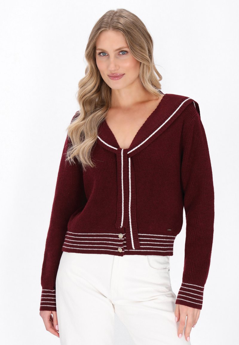 Cardigan a maglia bordeaux con colletto da marinaio, caratterizzato da strisce bianche e tre bottoni in vita. Texture morbida, vestibilità comoda.