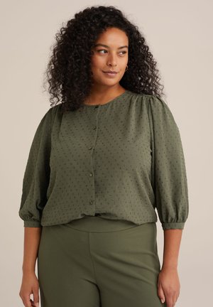 Olive green blouse with textured fabric, round neckline, button closure, and puffed sleeves. Paired with matching green pants.