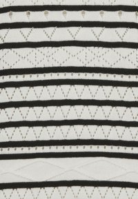 Knit fabric featuring black and white horizontal stripes, with eyelet patterns and metallic accents, creating a textured and layered design.