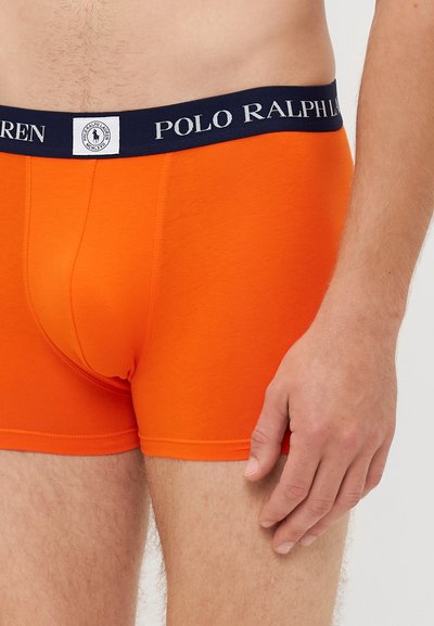 Boxeri scurti Polo Ralph Lauren, portocalii, cu un elastic bleu închis ce prezintă un logo imprimat, confecționați din bumbac moale, cu o croială strânsă și o textură netedă.
