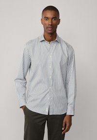Gestreepte overhemden in wit, lichtblauw en marineblauw. Regular fit met een kraag en lange mouwen, voorzien van knoopsluitingen en een subtiele textuur.