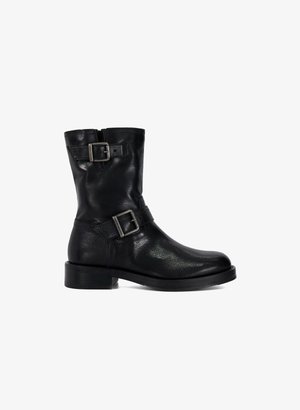 Zwarte leren enkelboot met een ronde neus, hoogte tot de kuit, zijrits en twee decoratieve gespen. Platte rubberen zool.