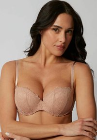 Kanten balconette-beha in zacht nude met gladde contourcups, verstelbare satijnen banden en gekartelde kanten afwerking.