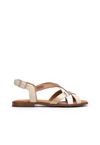 Beige en gouden leren sandalen met een kruisbandontwerp, verstelbare enkelgesp en een platte zool met houtstructuur. Gladde en gestructureerde materialen.
