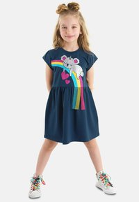 Marineblaue Baumwollkleid mit kurzen Ärmeln, das ein Koala- und Regenbogenmotiv zeigt, sowie einem gefältelten Rock. Akzente in Regenbogenfarben am Saum.