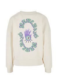 Krémová mikina s veľkým fialovo-zeleným grafickým motívom na chrbte, ktorý zobrazuje rukovú designu a slovo "KARL KANI" v vlnitom písme.