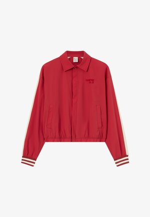 Czerwona lekka kurtka z kołnierzem, elastycznym dołem, dwoma przednimi kieszeniami, paskowanymi mankietami oraz subtelnym wyszywanym logo na lewej piersi.