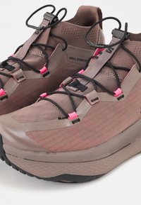 Καφέ και ροζ παπούτσια για τρέξιμο σε μονοπάτια με μαύρο ρυθμιζόμενο σύστημα γρήγορου κορδονιού και επάνω μέρος από δίχτυ, με την ένδειξη "GRVL CONCEPT" στο πλάι.