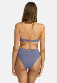 Bikini blu e arancione con motivo, top senza spalline e slip alta vita, che mostra una finitura testurizzata e una chiusura metallica sul retro.