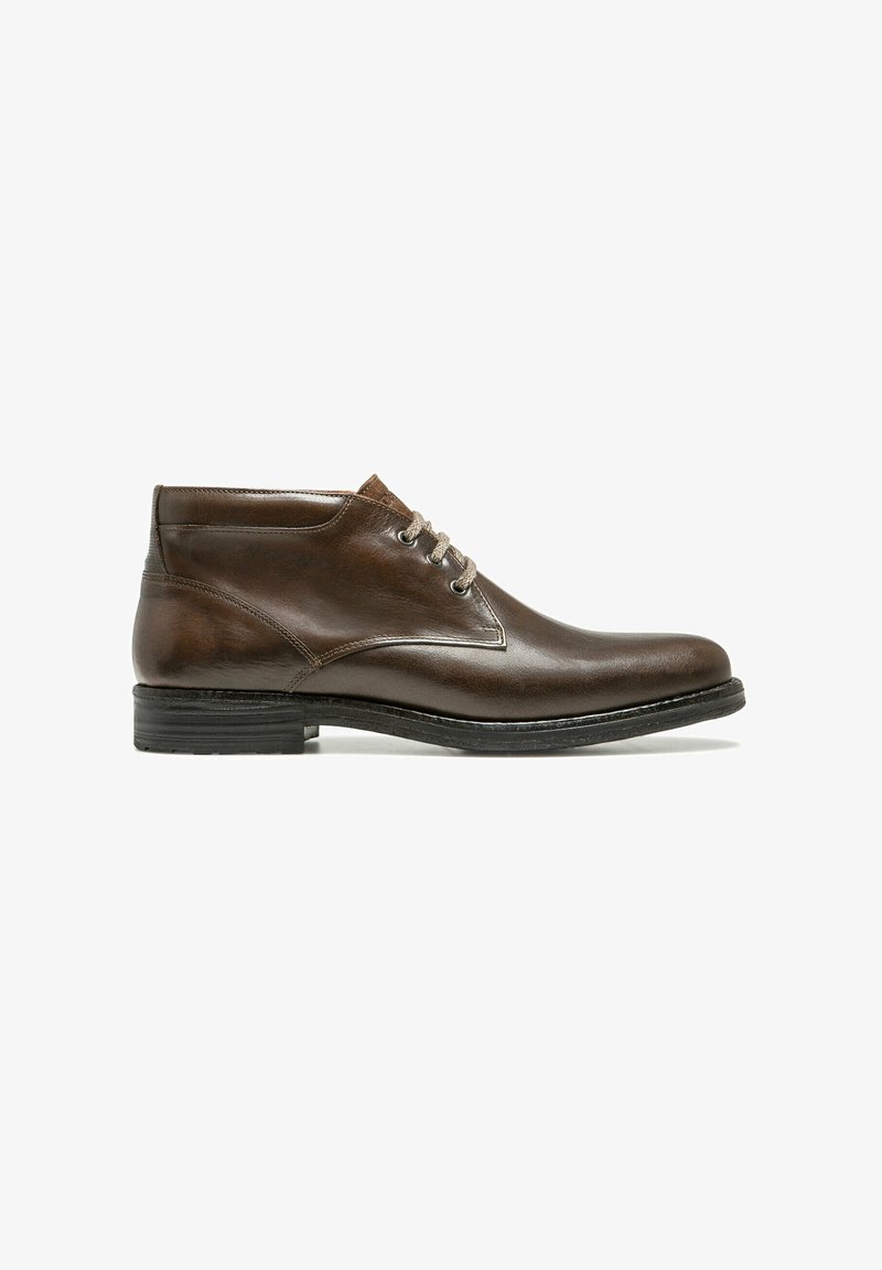 Bottine en cuir brun avec bout arrondi, lacets beiges et semelle noire, présentée de profil sur un fond blanc.