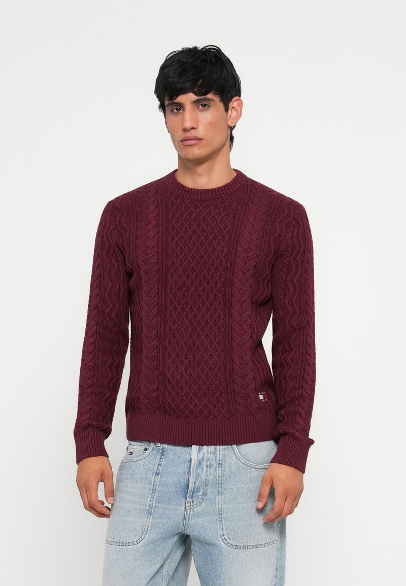 Pullover de malha borgonha com um padrão de cabo texturizado, gola redonda com nervuras e punhos justo. Etiqueta da marca notável na bainha.