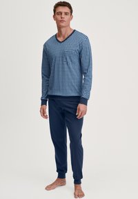 Heren loungewear set bestaande uit een gemêleerd blauwe lange mouw top met V-hals en marineblauwe elastische taillebroek met boorden. Het materiaal is een zachte katoenmix.