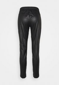 Svarta byxor i konstläder med elastisk midja. Slim fit med slät textur, utan utsmyckningar, vilket ger en elegant och oavbruten design.