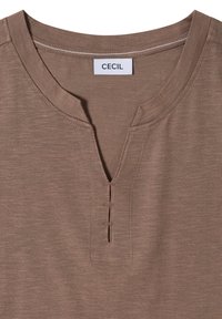 Chemise marron à manches courtes avec un col rond et une encoche en V avec une couture décorative sous le col.