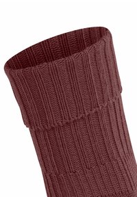 Chaussette tricotée rouge foncé avec une texture côtelée et un revers, positionnée en angle sur un fond blanc.