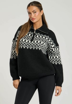 Zwart-wit gemusterd gebreid sweater met een halve ritssluiting, oversized silhouet en ribbelboorden. Warm, textuurrijk materiaal.