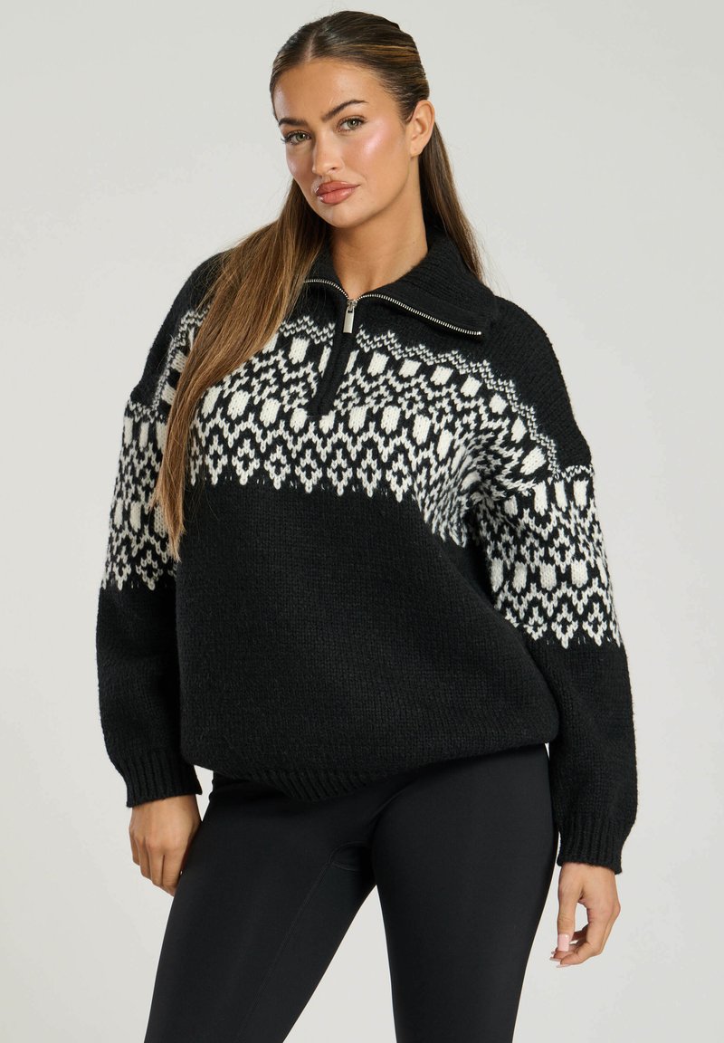 Zwart-wit gemusterd gebreid sweater met een halve ritssluiting, oversized silhouet en ribbelboorden. Warm, textuurrijk materiaal.