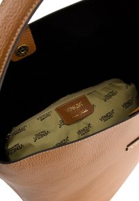 Brązowa torba tote z teksturowanej skóry, z okrągłym otworem. Wnętrze wyłożone beżowym materiałem z nadrukowanym logo "VENEZIA" oraz kieszenią na zamek.