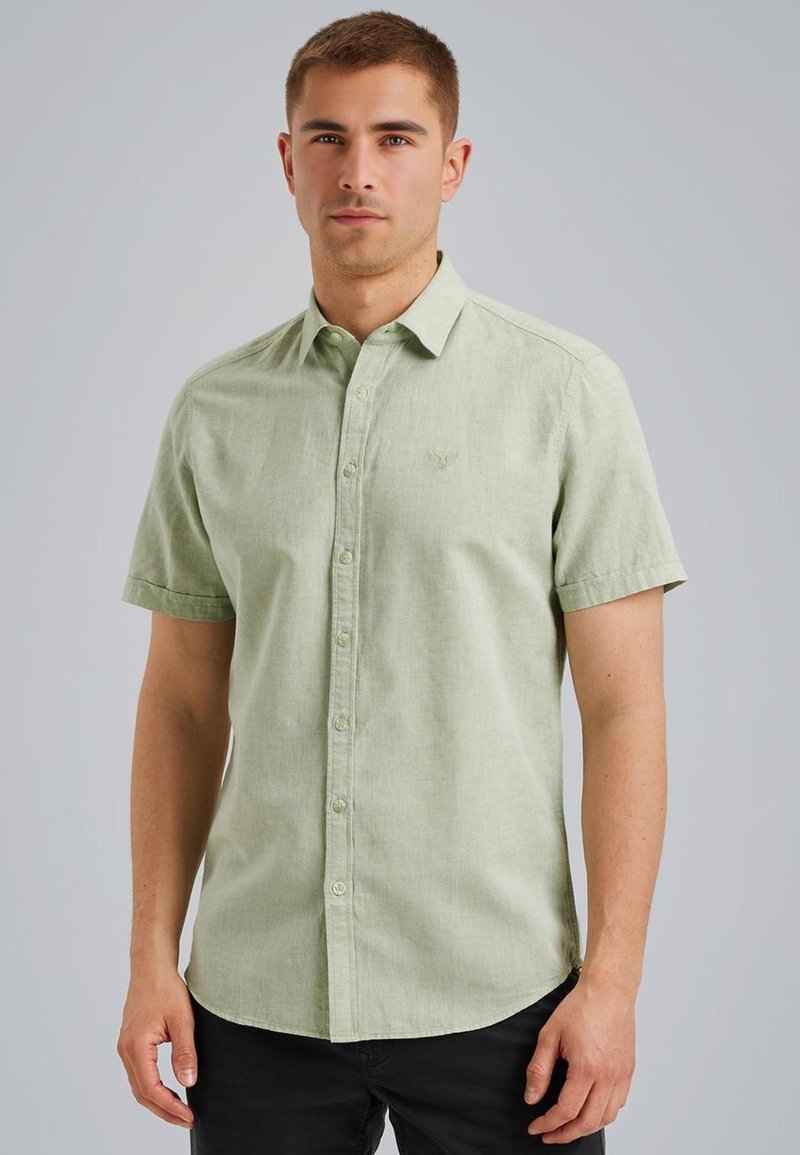 Korte mouwen, lichtgroene blouse met een gestructureerde stof, subtiel logo op de borst en een gebogen zoom.