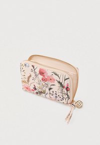 Portefeuille floral avec fermeture éclair, doté d'une base rose pastel, de ferrures dorées et de motifs floraux complexes de différentes couleurs.