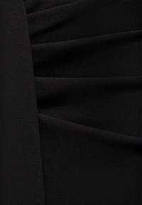 Zwarte jurkstof met zachte, gestructureerde plooien die verticaal zijn gerangschikt. Het materiaal lijkt lichtgewicht met een gladde afwerking.